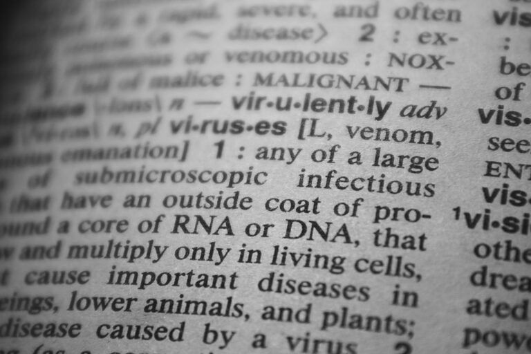 Black and white close-up of a dictionary page focusing on the definition of 'virus'.