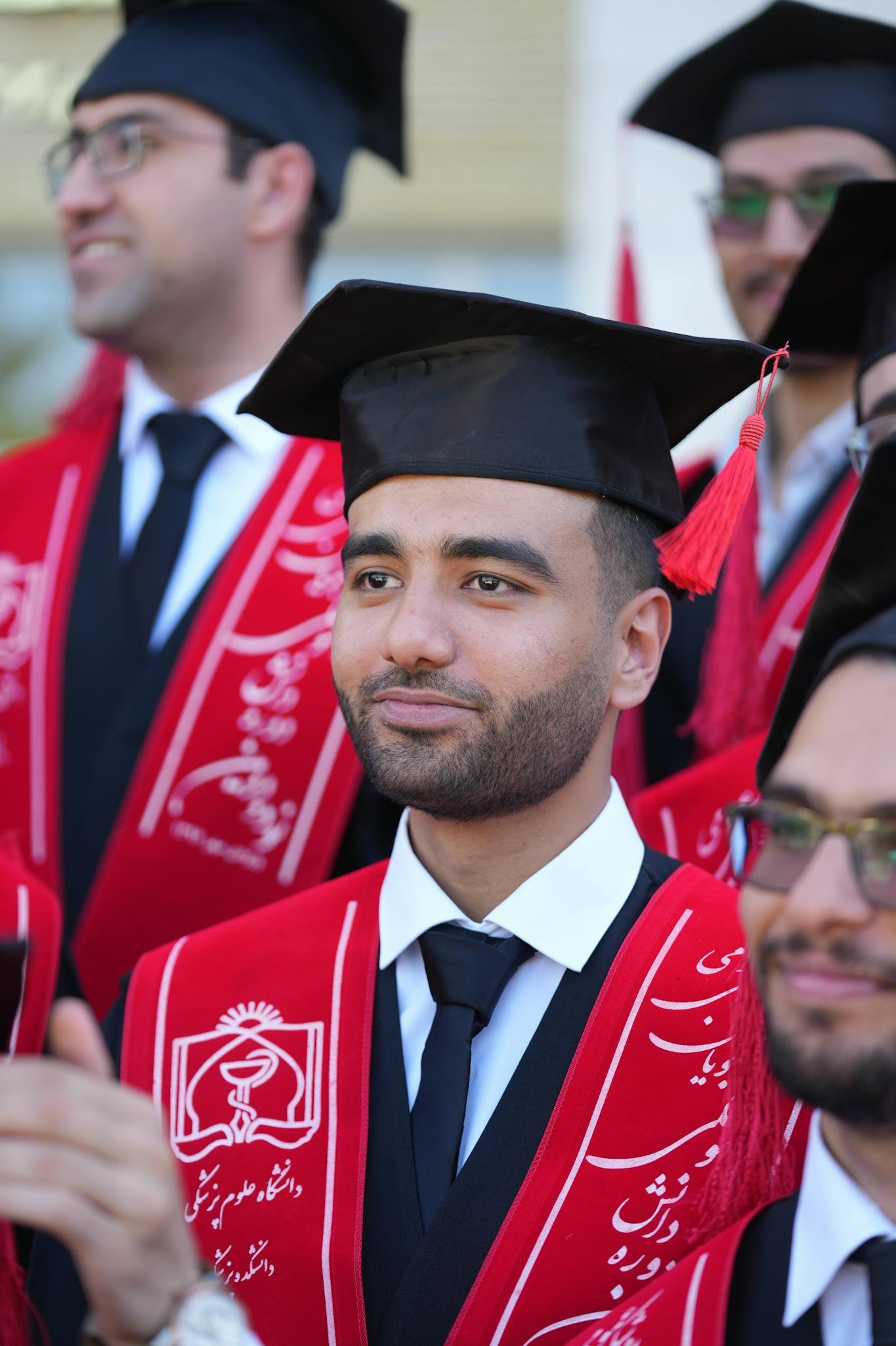 Happy graduates in caps and gowns celebrating their achievement outdoors.